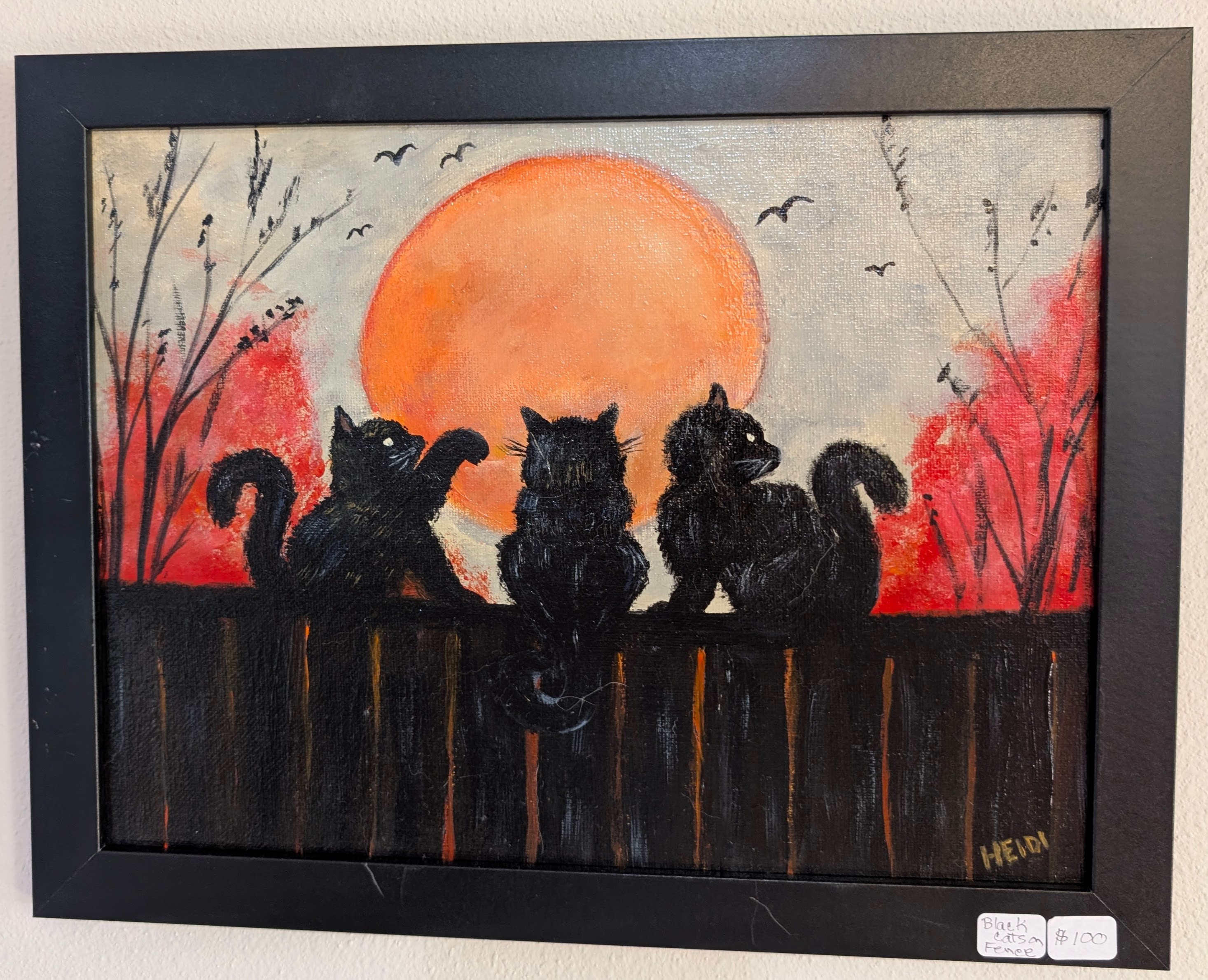Three black cats on a fence with a large orange sun and autumn trees